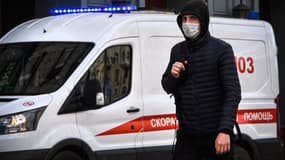 Un homme portant un masque à côté d'une ambulance à Moscou, en Russie, le 23 mars 2020