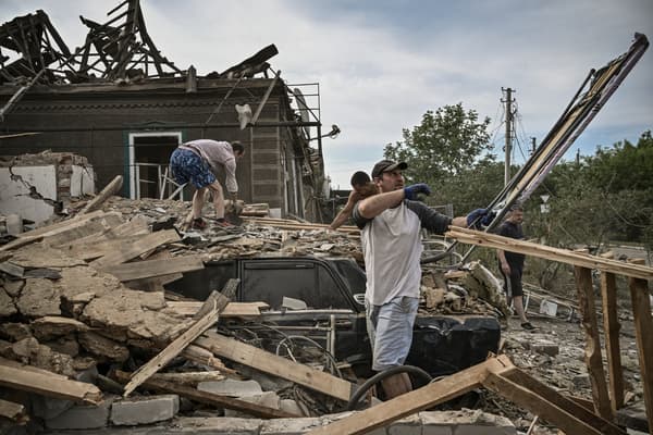 Residents evacuate a house hit by a rocket in Druzhkivka, Donbass, Ukraine, June 5, 2022