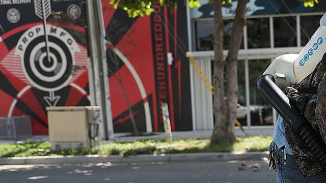 Un homme chasse les moustiques dans le quartier de Wynwood, à Miami.