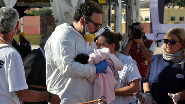 Un membre de l'ONG SOS Méditerranée tenant un bébé après une opération de secours en mer, le 13 octobre 2017.