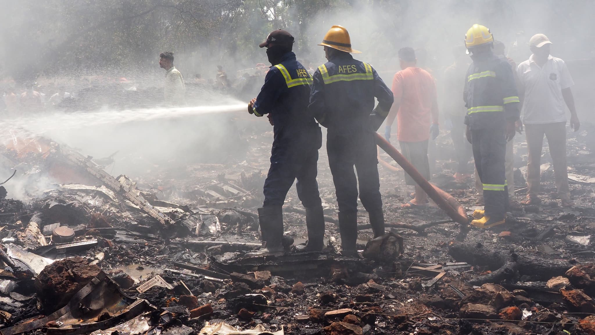 Des pompiers sur le site où l'avion 171 d'Air India s'est écrasé dans une zone résidentielle près de l'aéroport d'Ahmedabad, le 12 juin 2025.