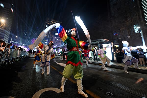 Des danseurs traditionnels sud-coréens participent à un défilé dans le cadre du compte à rebours du Nouvel An dans le centre de Séoul, avant minuit, le 31 décembre 2023.