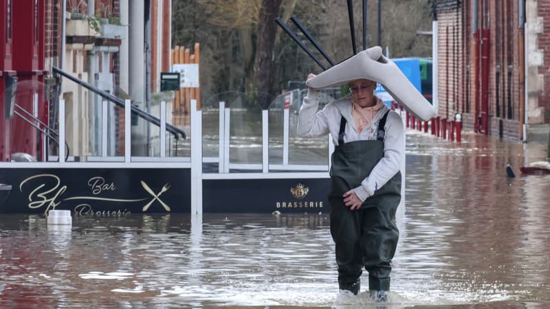 Un habitant marche dans une rue inondée d'Arques, dans le Pas-de-Calais, le 4 janvier 2024