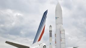 La dérive d'un avion Air France à côté de maquettes des fusées Ariane 1 (g) et Ariane 5 (d) au salon international aéronautique et de l'espace à l'aéroport Paris-Le Bourget, le 18 juin 2023