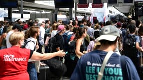 Une employée de la SNCF guide les voyageurs à la gare de Lyon, à Paris, lors du chassé-croisé des juilletistes et aoûtiens, le 29 juin 2022