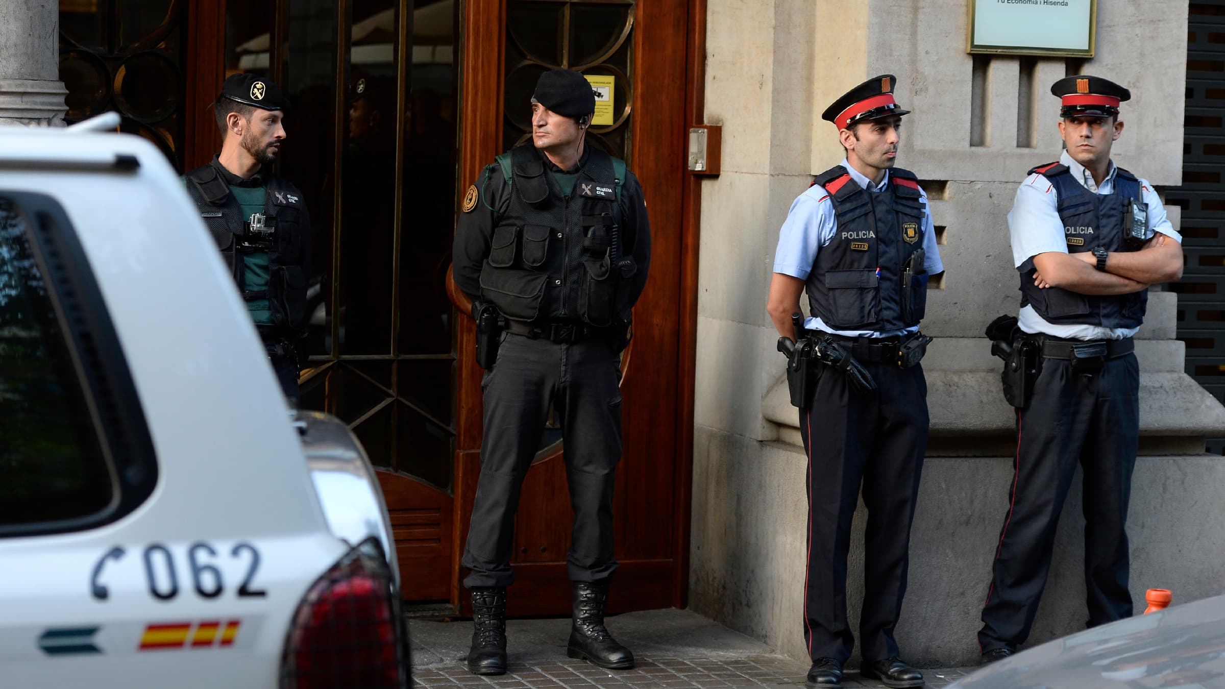 Des membres de la Guardia Civil et des Mossos d'Esquadra surveillent les locaux du gouvernement catalan, pendant des perquisitions, le 20 septembre, à Barcelone. Des membres de la Guardia Civil et des Mossos d'Esquadra surveillent les locaux du gouvernement catalan, pendant des perquisitions, le 20 septembre, à Barcelone.