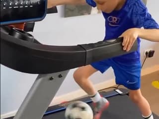 Une jeune footballeur s'entraînant sur un tapis de course