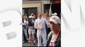 Le chanteur Pierre Garnier devant l'Olympia à Paris, la flamme olympique à la main.