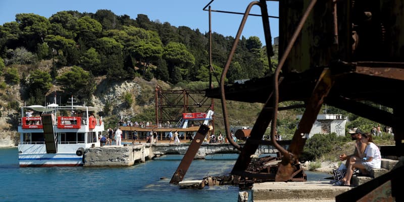 Des touristes débarquent d'un bateau amarré dans un port de l'île de Sazan, au large de l'Albanie, le 30 juillet 2024 (photo d'illustration).
