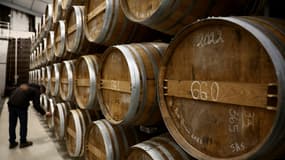 Des fûts de cognac dans la cave d'un producteur à Jarnac-Champagne, le 20 mars 2025