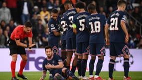 Lionel Messi allongé au sol derrière le mur parisien