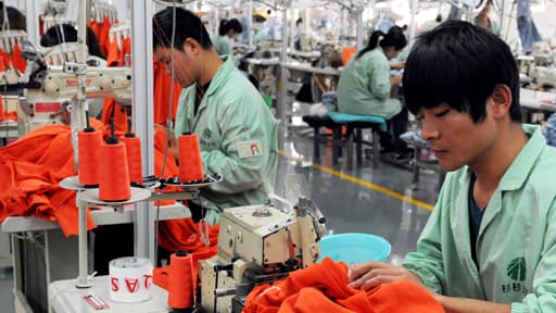 Des travailleurs font de la couture dans une usine de textiles à Bozhou, dans l’Est de la Chine.