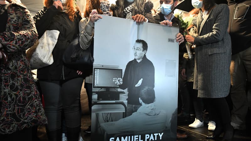 Des participants à la marche blanche en hommage à Samuel Paty portant une photo du professeur. 