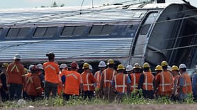 Des secouristes devant le train qui a déraillé mardi soir à Philadelphie tuant six personnes.