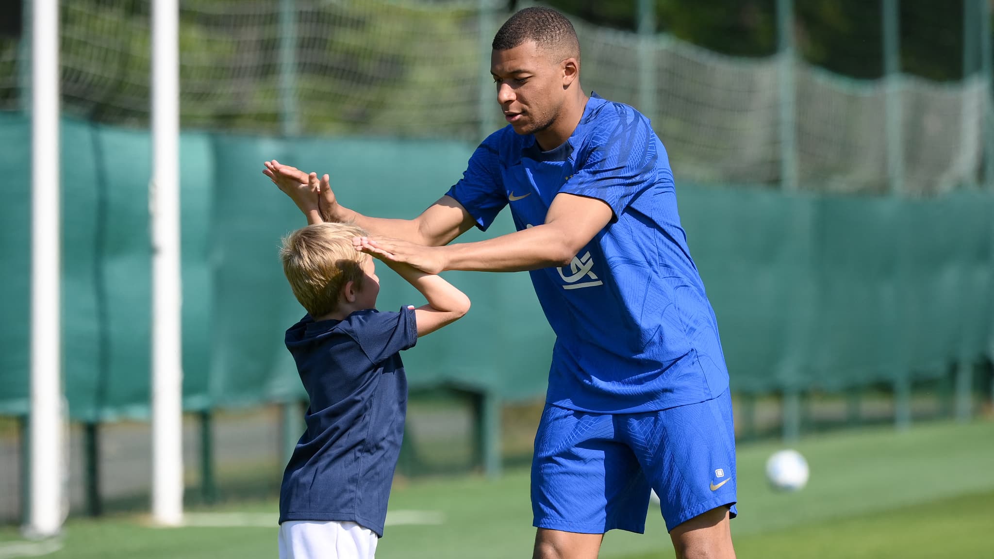Un enfant avec Kylian Mbappé, à Clairefontaine le 14 juin 2023