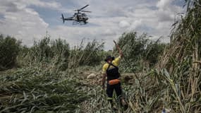 Des policiers sud-africains cherchent le corps d'un disparu dans des inondations le 11 février 2023