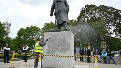 La statue de l'ancien Premier ministre britannique Winston Churchill est nettoyée pour ôter un graffiti selon lequel il "était un raciste", près du Parlement à Londres le 8 juin 2020