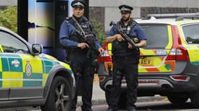 Des policiers armés surveillent le périmètre où s'est produit l'accident de la route, samedi 7 octobre 2017, à Londres