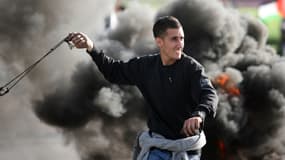 Un manifestant palestinien prêt à lancer une pierre contre les soldats israéliens, près du checkpoint de Jamala, le 24 février 2013.