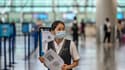Une employée de l'aéroport de Shanghai-Pudong tient un QR code pour vérifier l'état de santé des voyageurs, le 11 juin 2020 en Chine