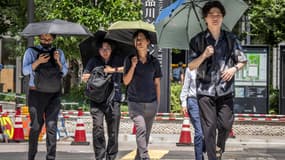 À Tokyo, le 27 août 2025, les gens se protègent du soleil brûlant à l'aide de parasols, la ville ayant connu 10 jours consécutifs de températures supérieures ou égales à 35 °C.
