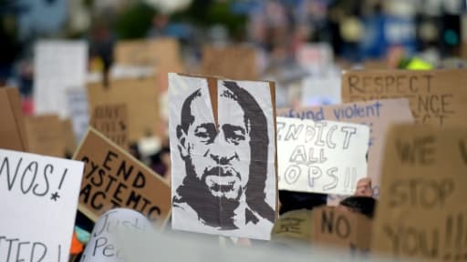 Des manifestants brandissent un portrait de George Floyd lors d'un rassemblement pour dénoncer le racisme et les violences policières, à Hollywood, le 7 juin 2020