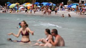 Des touristes profitent du soleil sur une plage de Santa Giulia près de Porto Vecchio, le 9 juillet 2023 en Corse.