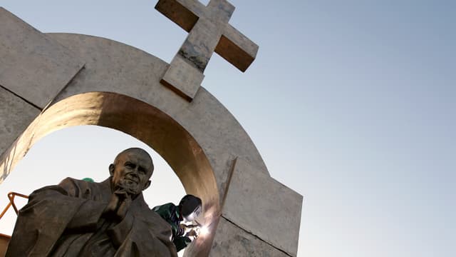Des ouvriers d'origine russe travaillent à l'installation d'une statue géante du pape Jean-Paul II, le 28 novembre 2006 à Ploërmel.