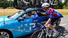 Michael Woods se ravitaille auprès de sa voiture lors de la 9e étape du Tour de France, le 13 juillet 2025