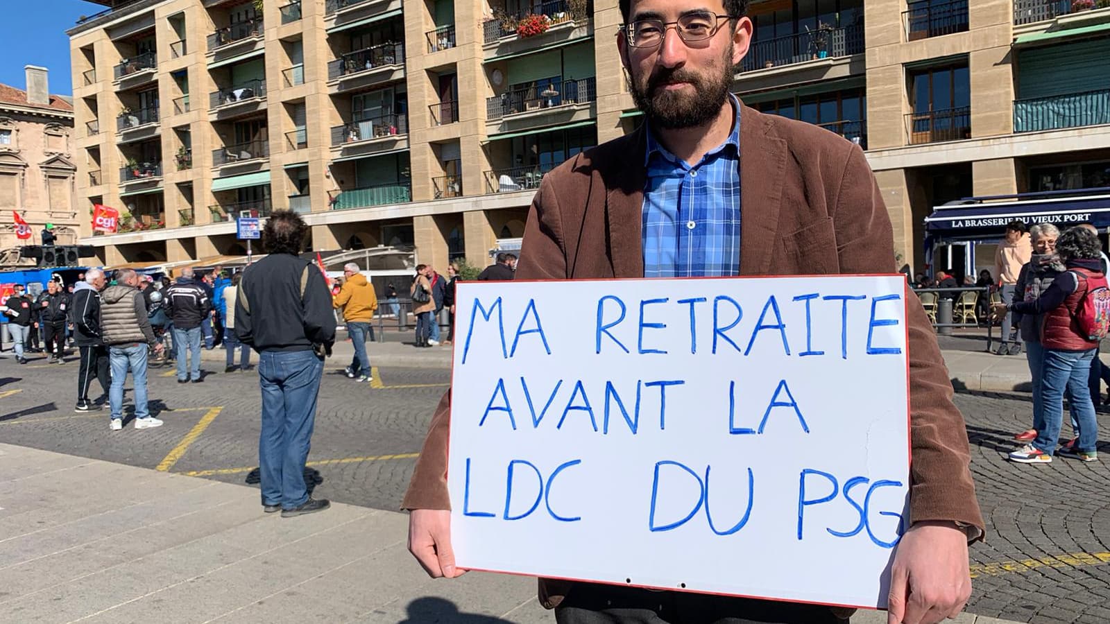 Un manifestant brandit une pancarte qui renvoie à la rivalité entre l'OM et le PSG lors de la manifestation contre la réforme des retraites à Marseille, le 13 avril 2023. 