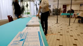 Un électeur en train de choisir des bulletins de vote à Cucq dans le nord de la France ce dimanche.