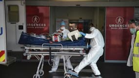 Des ambulanciers transportent au service des urgences de l'hôpital de Strasbourg un patient atteint du coronavirus, arrivé par avion de la région lyonnaise, le 6 novembre 2020