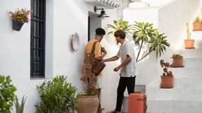 Deux hommes arrivant dans une maison louée pour les vacances. (Illustration)