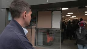 Anthony Castillo devant son magasin, dont la devanture a été brisée pendant les émeutes.