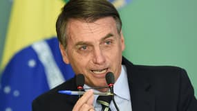 Jair Bolsonaro montre le stylo avec lequel il a signé le décret.