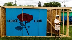 Une personne se tient devant une peinture rendant hommage à George Floyd à Minneapolis, dans le Minnesota, le 22 mai 2021