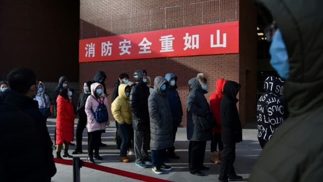 Personnes patientent pour réaliser un test du Covid-19 à l'extérieur d'un hôpital de Pékin, le 5 janvier 2021