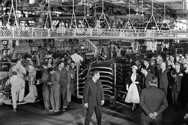 Queen Elizabeth II flanked by French carmaker Renault CEO Pierre Dreyfus visits the Renault car factory in Flins during a state visit in France on April 10, 1957.