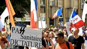 Un manifestant contre le pass sanitaire brandit une pancarte avec le mot pass tracé avec une graphie rappelant celle des Wafen-SS, la 14 août 2021 à Metz 
