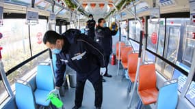 Une équipe d'agents d'entretien désinfectant un bus à Qingdao le 5 février 2020.