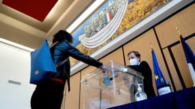 Une électrice glisse son bulletin pour la présidentielle française dans l'urne, à Washington, le 9 avril 2022