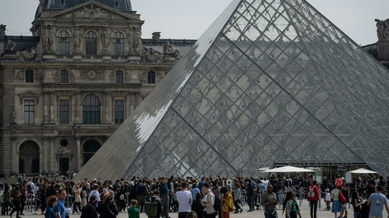 Des touristes font la queue devant la pyramide du Louvre le 29 avril 2022