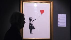 Une vue de l'œuvre de l'insaisissable artiste de rue Banksy, intitulée "La fille au ballon rouge", ainsi que plus de 130 autres œuvres sont exposées au musée de Barcelone, en Espagne, le 1er mai 2024. 