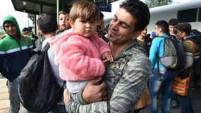 Un migrant, un enfant dans les bras, arrivé en train de Hongrie via Munich, sur le quai de la gare d'Eisenhuettenstadt, dans l'est de l'Allemagne, le 7 septembre 2015