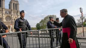 Monseigneur Chauvet devant le périmètre de sécurité établi autour de Notre-Dame de Paris. 