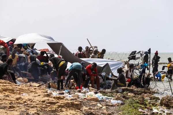 Des migrants subafricains, bloqués sur le bord de mer à la frontière entre la Libye et la Tunisie à Ras Jedir, sur une plage rocheuse le 26 juillet 2023.