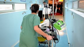 Une infirmière conduit un enfant dans un couloir d'hôpital. (Illustration)