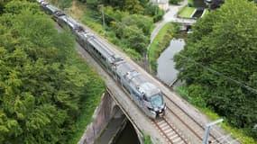 Cette photographie aérienne prise le 28 juillet 2023 montre un train express régional (TER) passant au-dessus du canal d'Ille et Rance, à Saint-Médard-sur-Ille, en Ille-et-Vilaine.