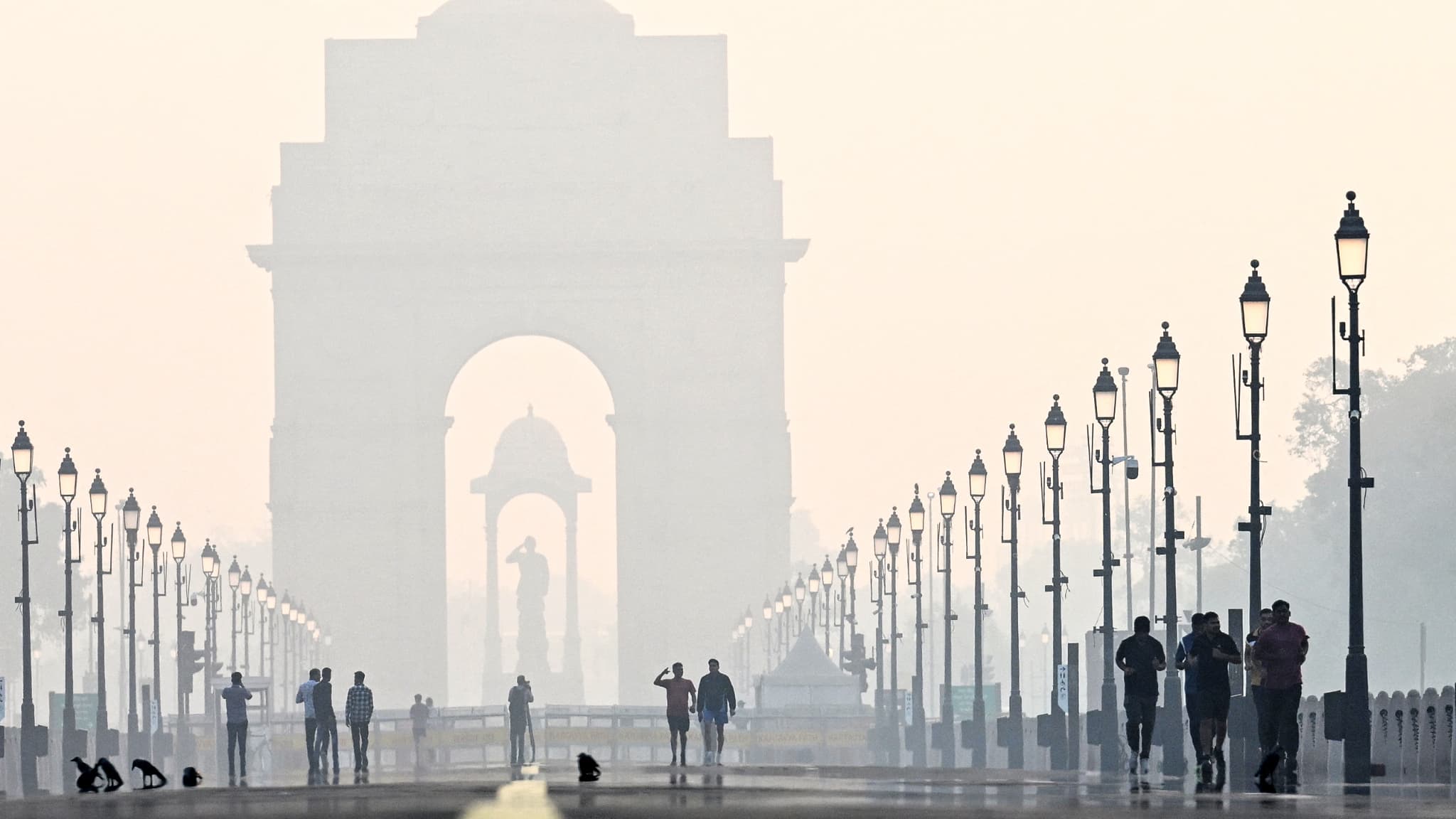 Des piétons marchent près de la Porte de l'Inde au milieu du smog après Diwali, le festival hindou des lumières, à New Delhi, le 1er novembre 2024.