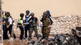 Des secouristes et des soldats israéliens devant un poste de police à Sderot le 8 octobre 2023